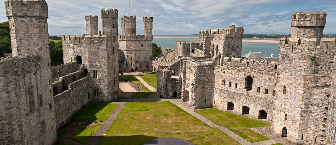 Caernarfon Castle stone towers and grounds beside the water