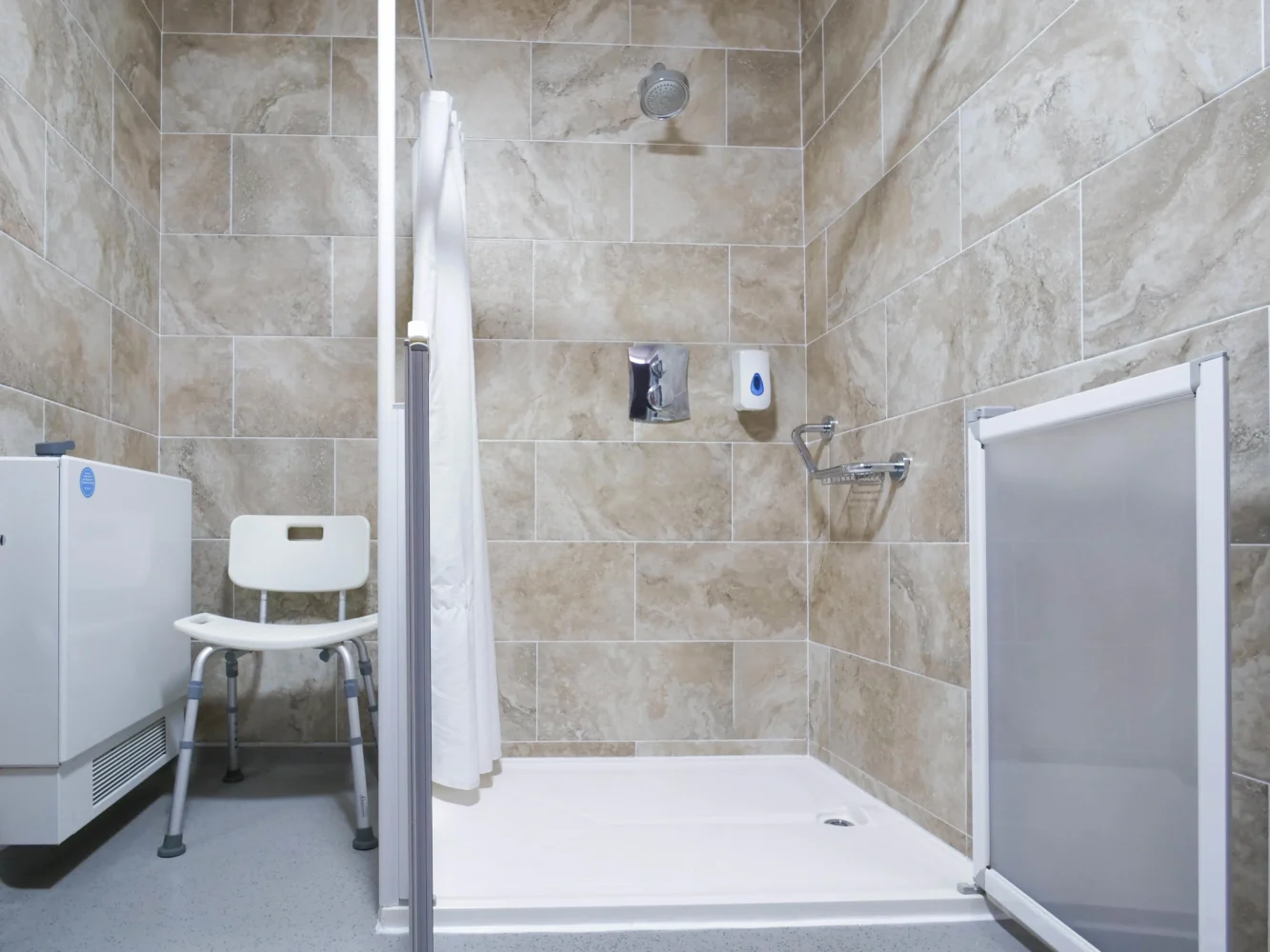 Tiled bathroom with shower cubicle, sink, and toilet