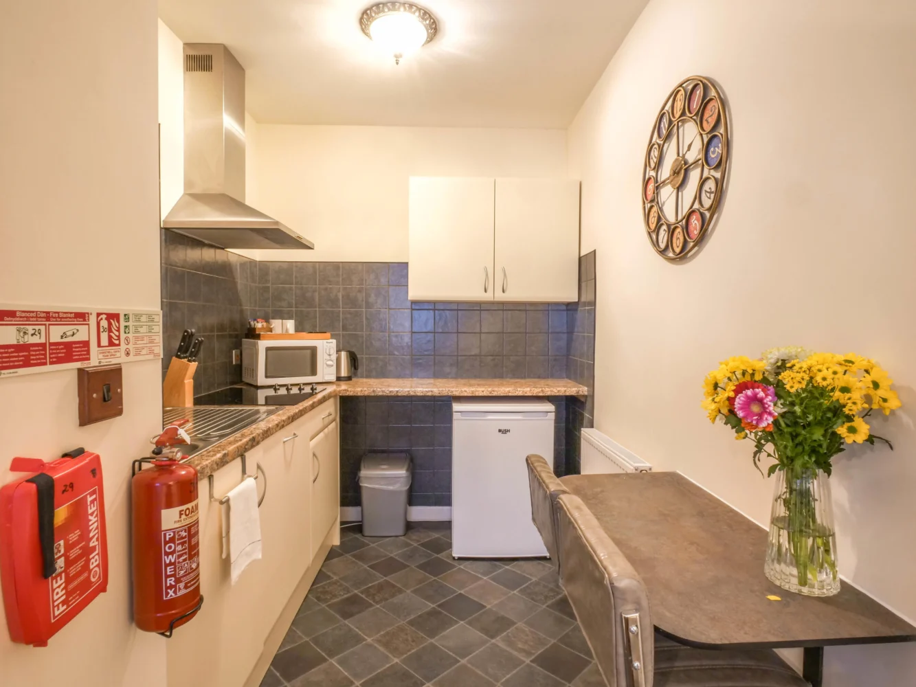 Self-catering kitchenette with dining table and flowers