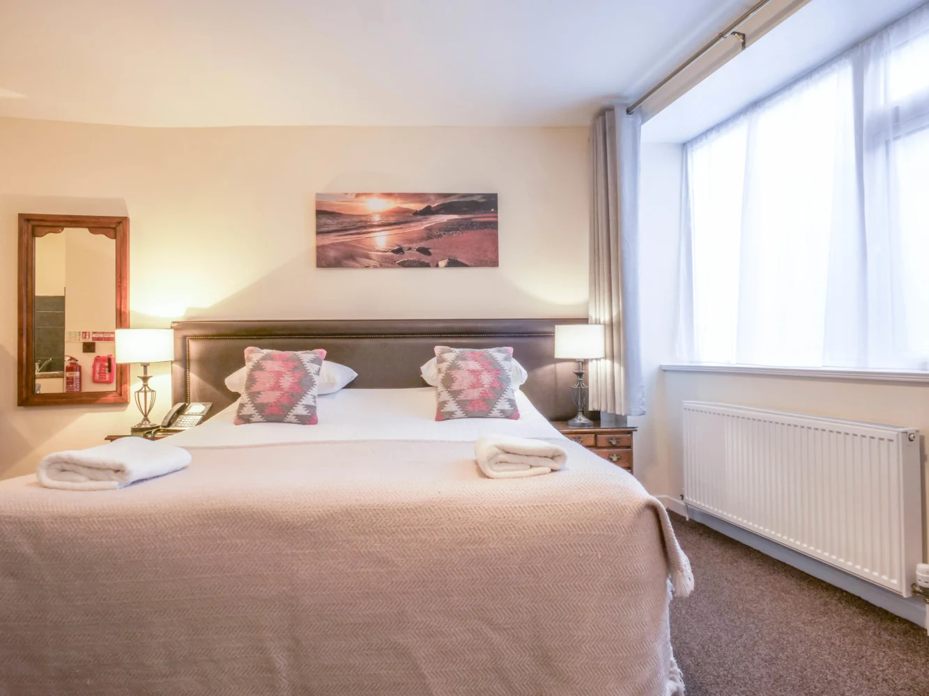 Hotel bedroom with double bed and patterned bedspread