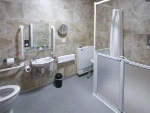 Modern tiled hotel bathroom with shower, sink, and toilet